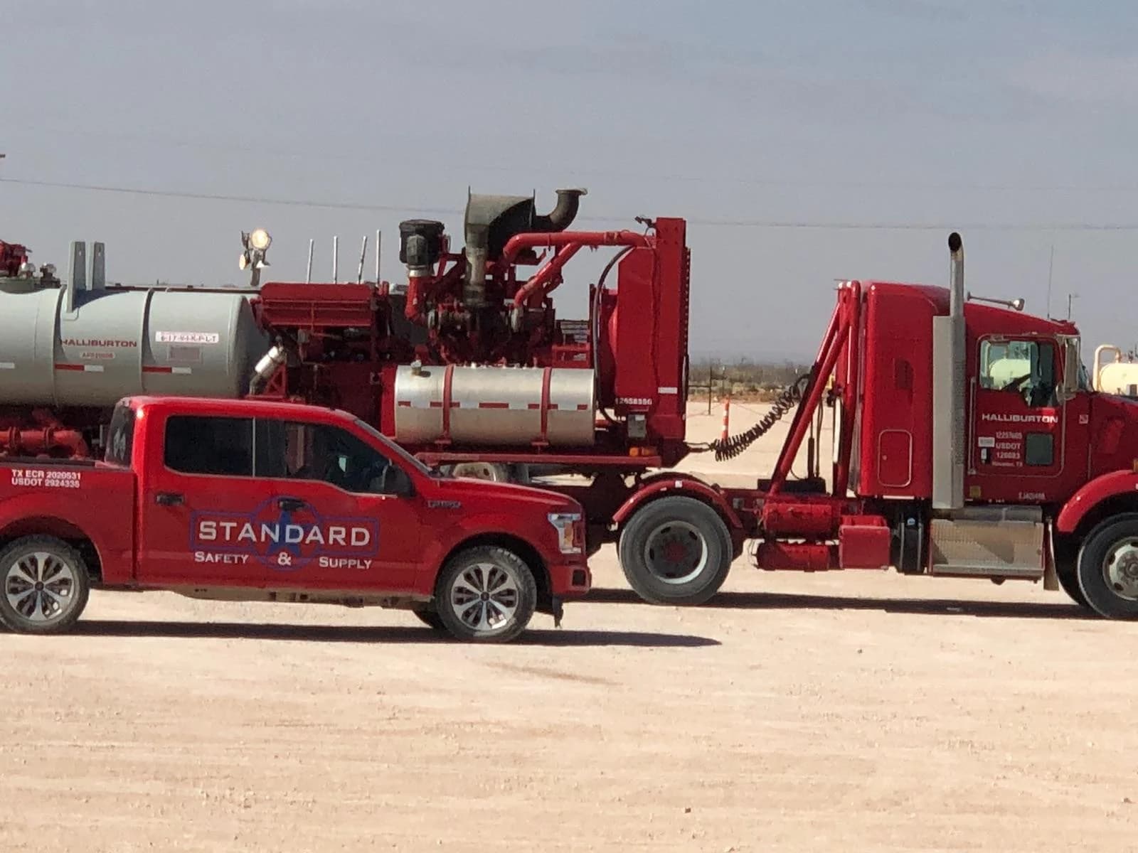 Standard Safety truck alongside heavy oilfield equipment
